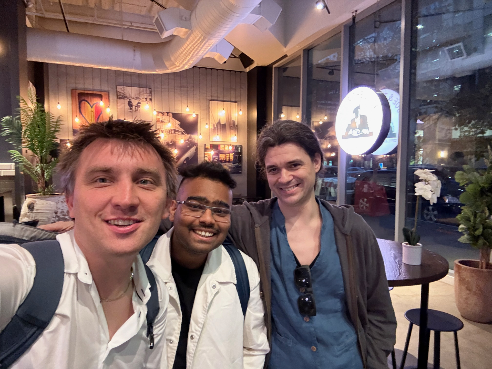 Three founders posing together at an evening meetup