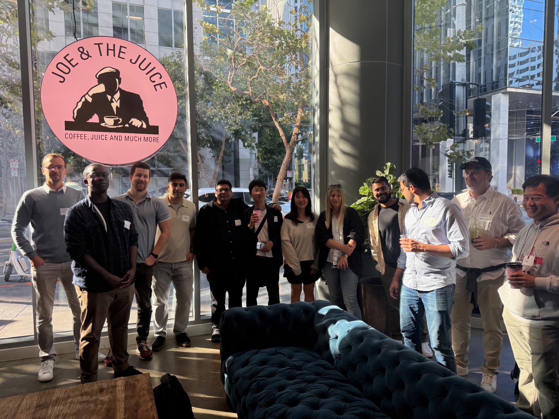 Large founder group photo under the pink Joe & The Juice sign