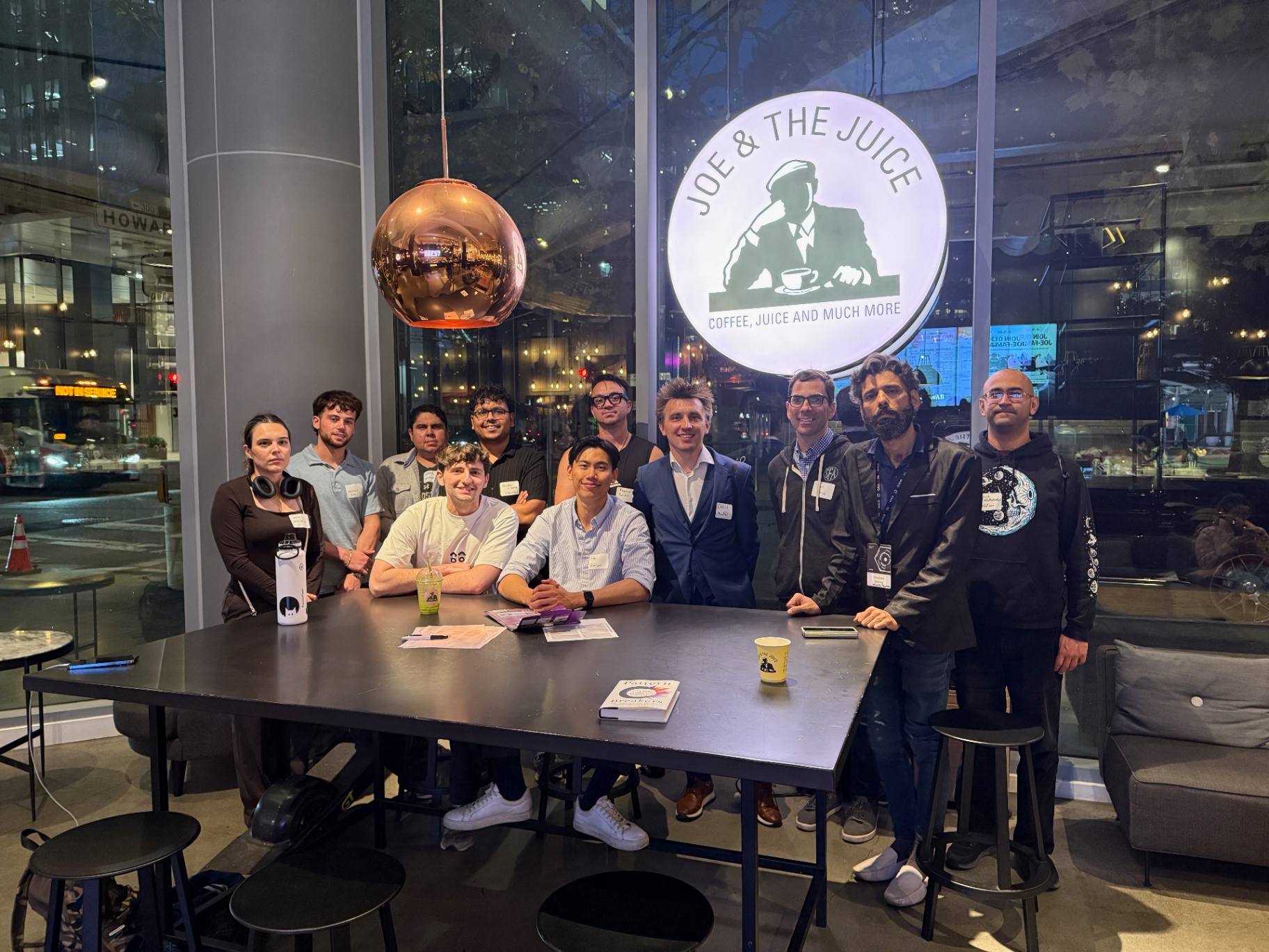 Founders posing around the table under the Joe & The Juice sign